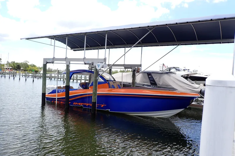 Slide: The Image of 2022 Deep Impact 369 Sport boat docked under a canopy at a marina. - 3