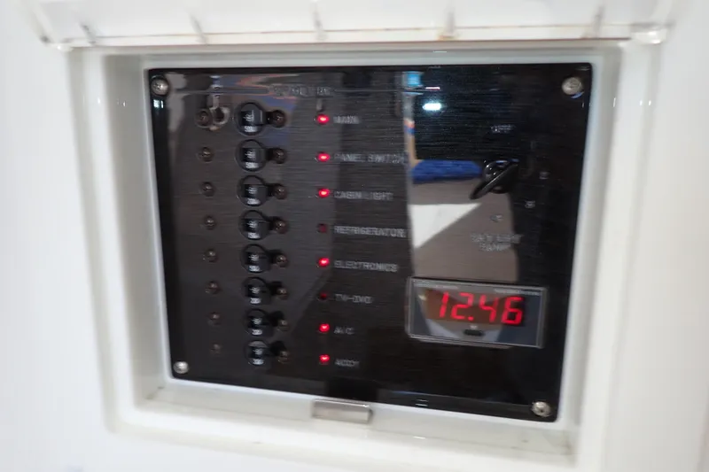 Slide: The Image of Electrical panel of 2022 Deep Impact 369 Sport boat, displaying switches and digital clock. - 38