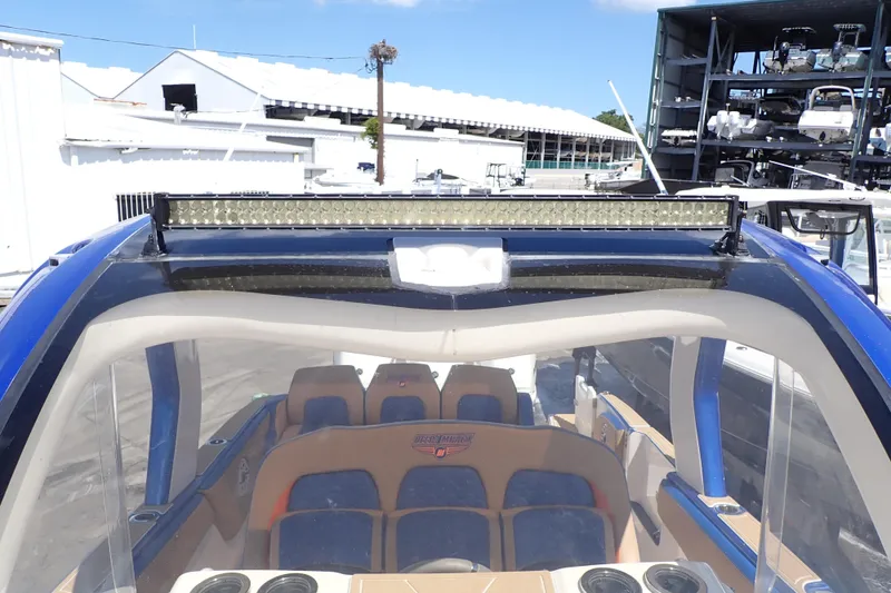 Slide: The Image of 2022 Deep Impact 369 Sport boat with blue accents and seating, docked at a marina. - 45