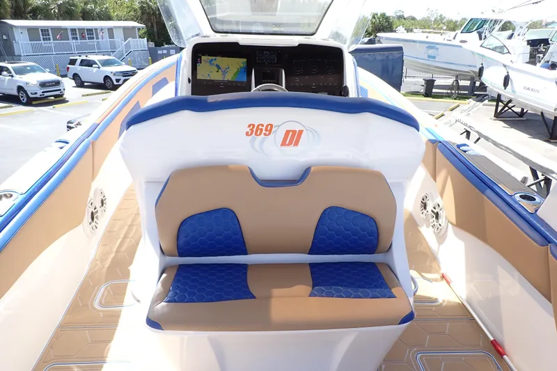 Slide: The Image of 2022 Deep Impact 369 Sport boat interior with blue and tan seating, dashboard, and navigation display. - 6