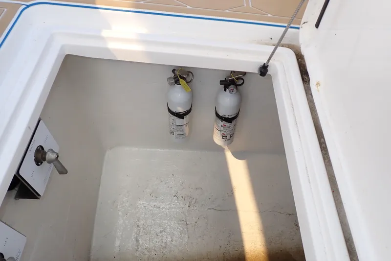 Slide: The Image of Storage compartment with fire extinguishers in a 2022 Deep Impact 369 Sport boat. - 69