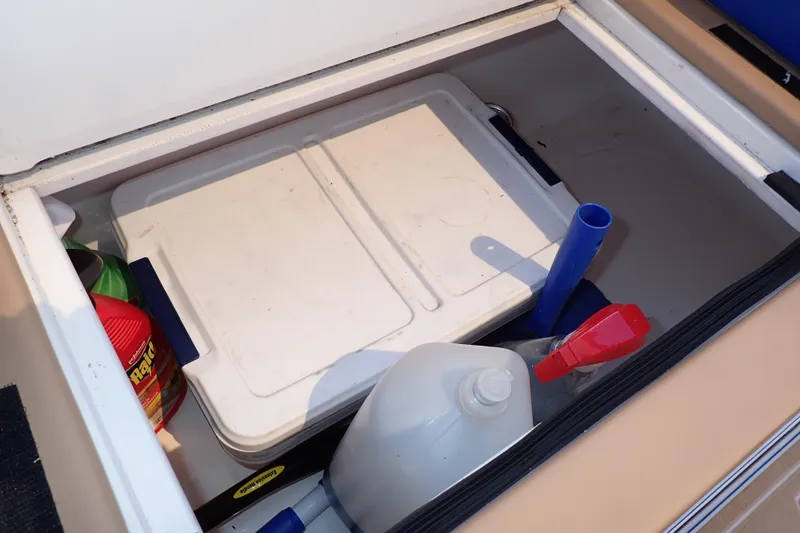 Slide: The Image of Storage compartment in a 2022 Deep Impact 369 Sport boat with cleaning supplies and cooler. - 73