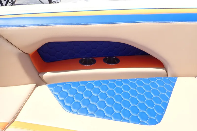 Slide: The Image of 2022 Deep Impact 369 Sport boat interior with blue and orange hexagonal upholstery and cup holders. - 84