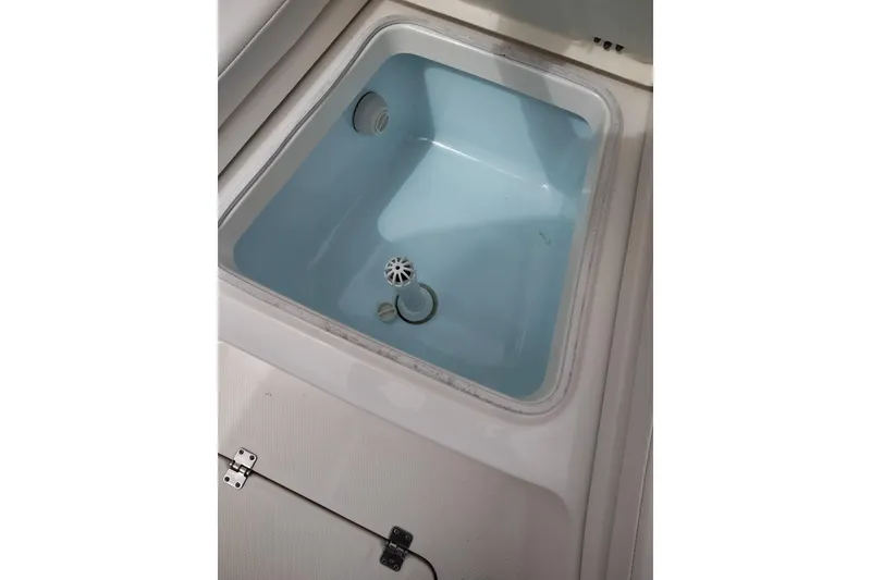 Slide: The Image of Livewell compartment in a 2021 Robalo 226 Cayman boat, featuring a clean, blue interior. - 19