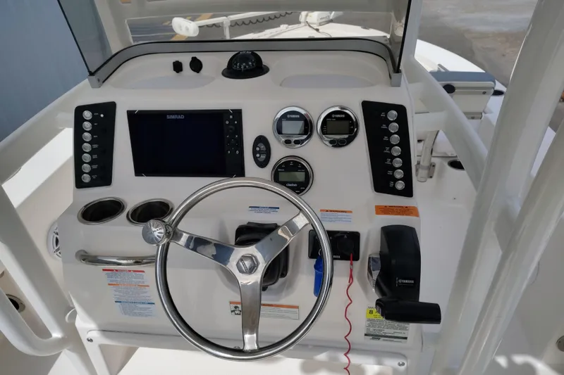 Slide: The Image of 2021 Robalo 226 Cayman boat dashboard with steering wheel, controls, and navigation display. - 6