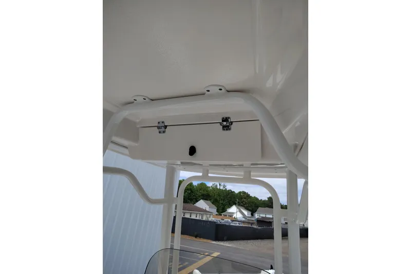 Slide: The Image of 2021 Robalo 226 Cayman boat T-top storage compartment, white frame, outdoor setting. - 7