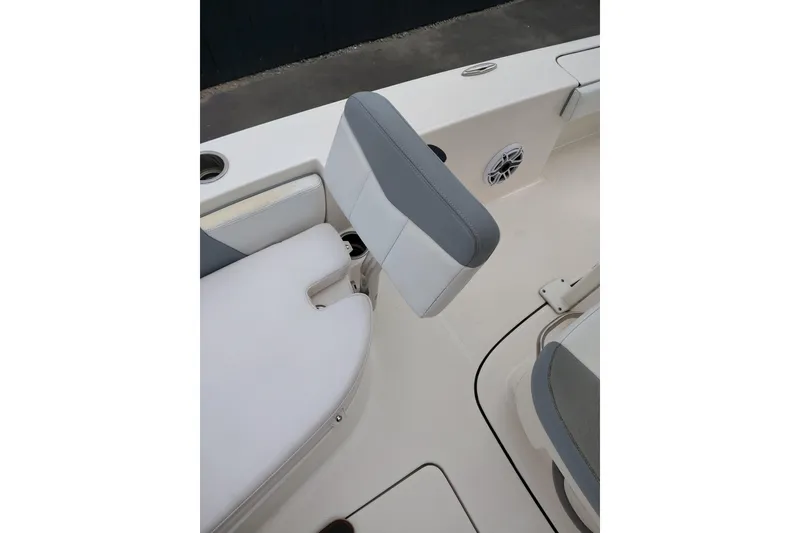 Slide: The Image of 2021 Robalo 226 Cayman boat interior with cushioned seating and speaker detail. - 9