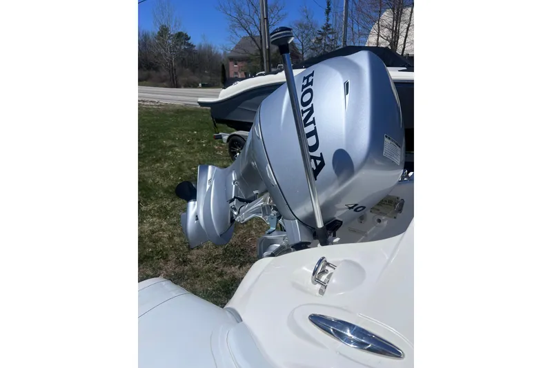 Slide: The Image of Honda outboard motor on 2016 Brig Eagle 340 boat, parked on grass. - 12