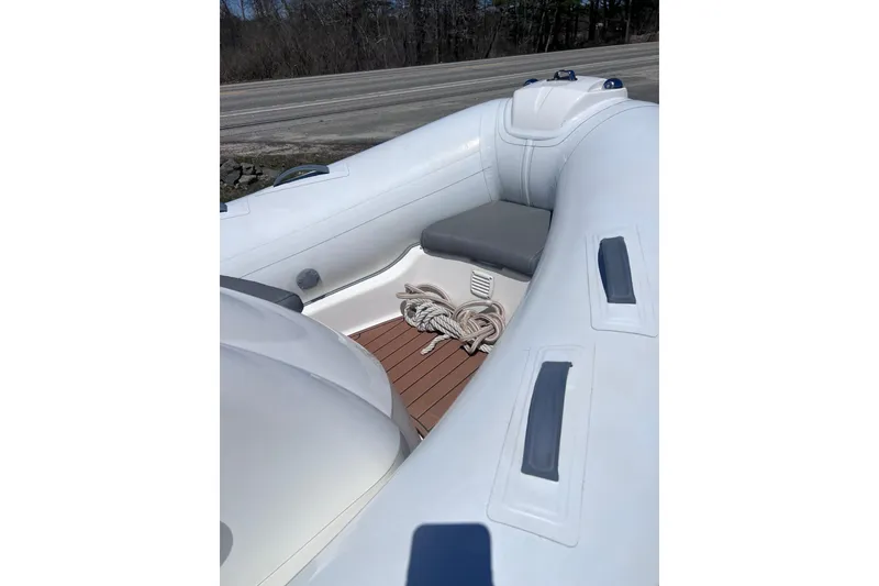 Slide: The Image of 2016 Brig Eagle 340 inflatable boat interior with rope on wooden deck. - 15