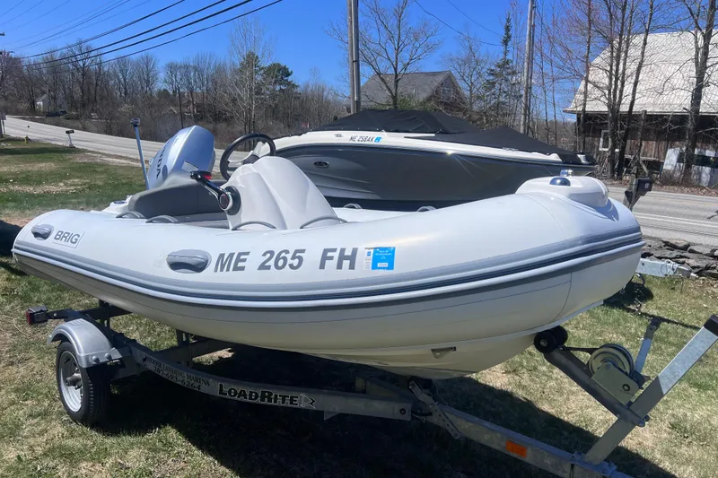 Slide: The Image of 2016 Brig Eagle 340 inflatable boat on trailer, parked outdoors. - 6
