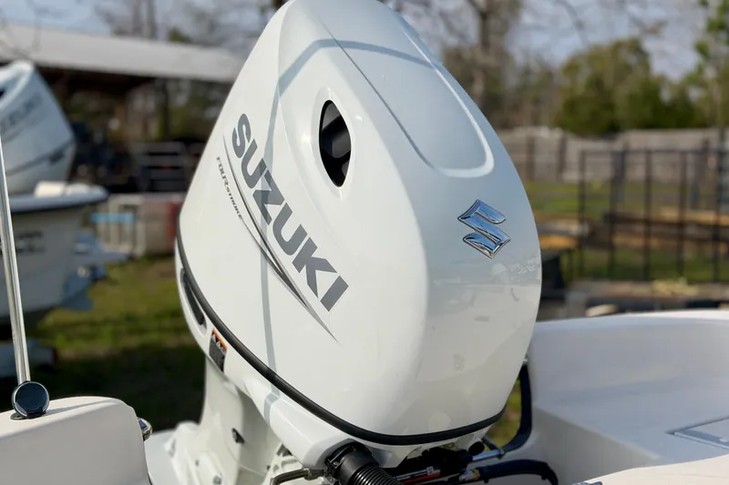Slide: The Image of Suzuki outboard motor on a 2026 Carolina Skiff 21 LS boat, outdoor setting. - 4