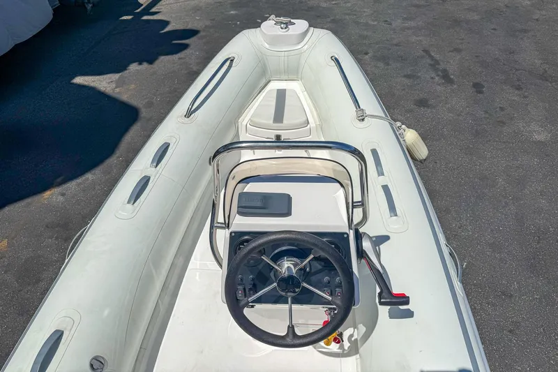Slide: The Image of 2021 AB Inflatables Oceanus 14 VST boat, white interior, steering wheel, docked on pavement. - 13