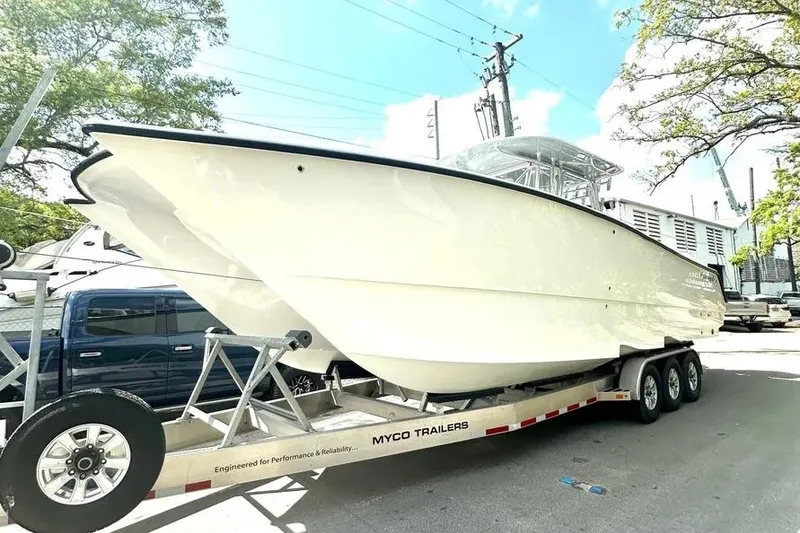 Slide: The Image of 2022 Freeman 34VH boat on Myco trailer, parked outdoors under clear sky. - 15