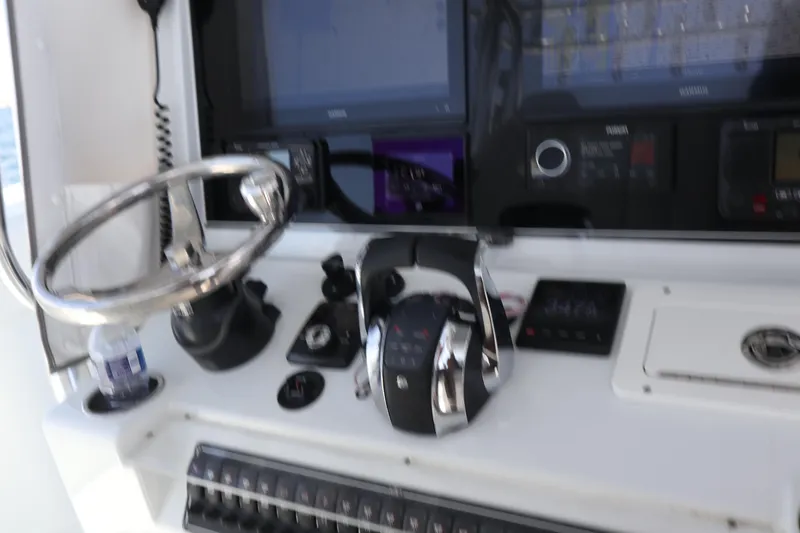 Slide: The Image of Control panel of a 2022 Freeman 34VH boat with steering wheel and navigation equipment. - 22