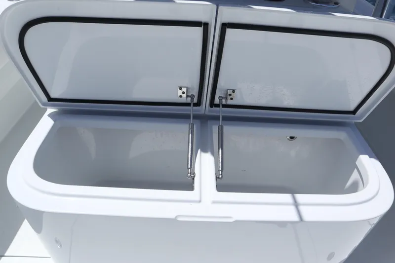 Slide: The Image of Open storage compartment on 2022 Freeman 34VH boat, featuring dual lids and hydraulic supports. - 26