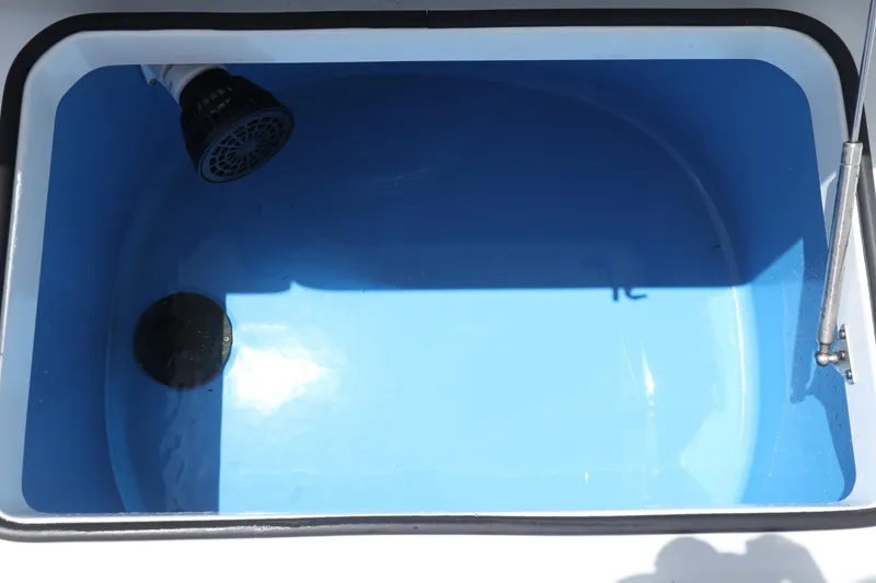 Slide: The Image of Blue livewell in a 2022 Freeman 34VH boat, featuring a drain and water inlet. - 28