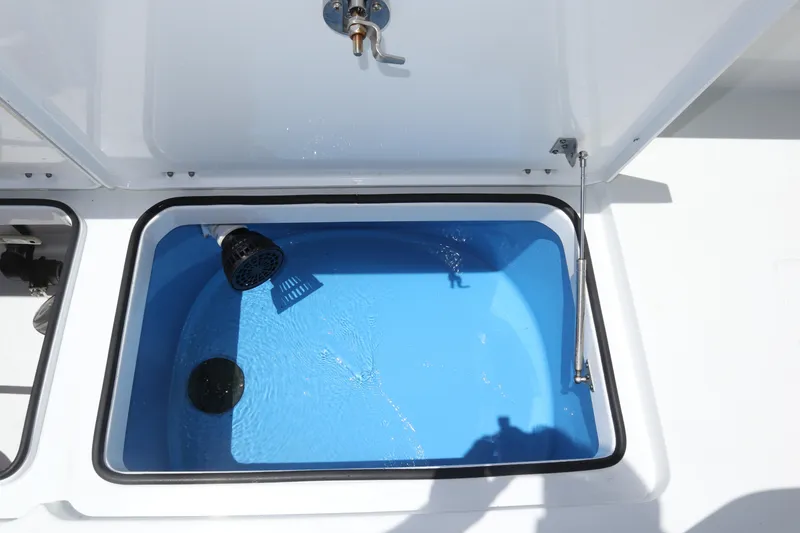 Slide: The Image of Livewell compartment on a 2022 Freeman 34VH boat, featuring a blue interior and water circulation system. - 31