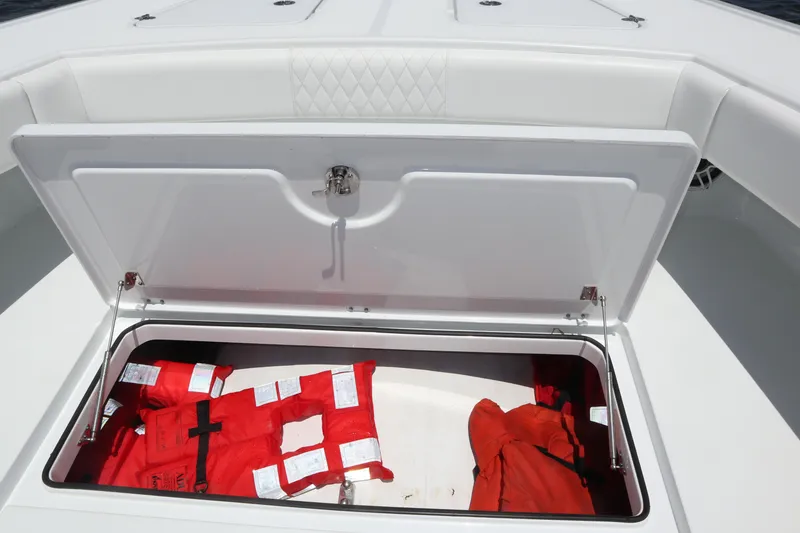 Slide: The Image of Open storage compartment on 2022 Freeman 34VH boat with red life jackets inside. - 34
