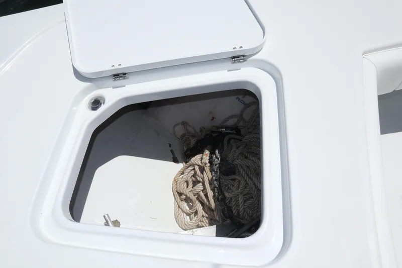 Slide: The Image of Open storage compartment on 2022 Freeman 34VH boat with coiled rope inside. - 35