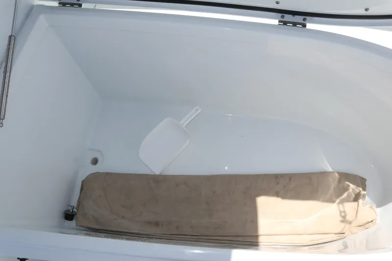Slide: The Image of Storage compartment of 2022 Freeman 34VH boat with a white scoop and beige cushion. - 41