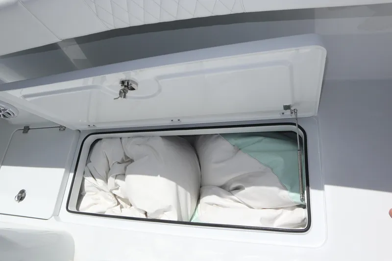 Slide: The Image of Open storage compartment on a 2022 Freeman 34VH boat, containing white fabric. - 42