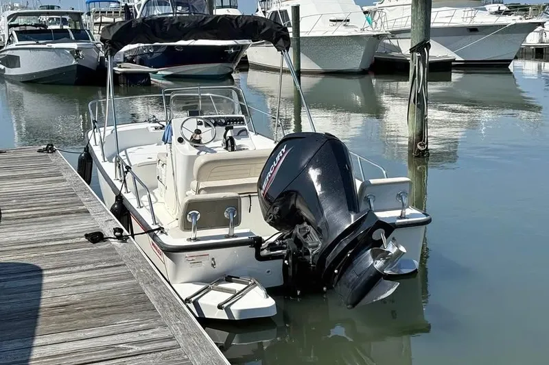 The Image of 2022 Boston Whaler 170 Montauk boat docked in marina with Mercury outboard motor. - 1