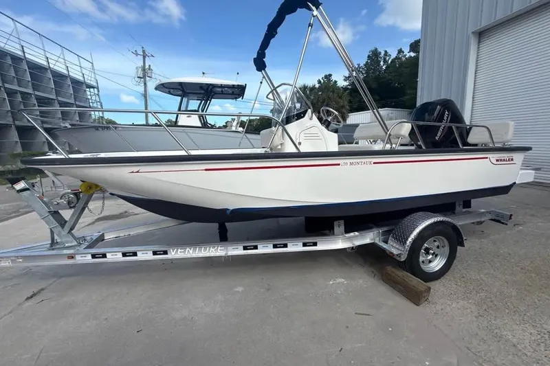 Slide: The Image of 2022 Boston Whaler 170 Montauk boat on trailer, parked outdoors. - 14