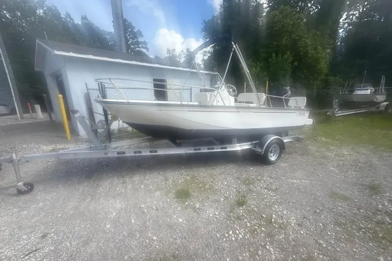 Slide: The Image of 2022 Boston Whaler 170 Montauk boat on trailer, parked outdoors near a building. - 16