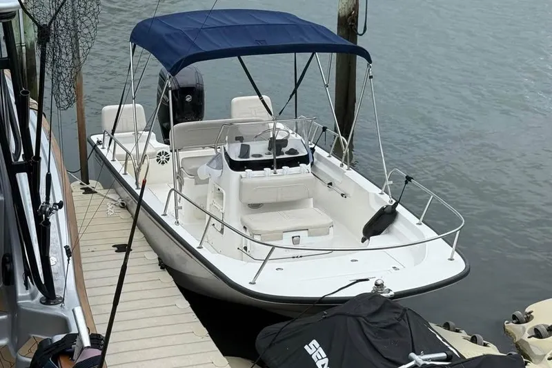 Slide: The Image of 2022 Boston Whaler 170 Montauk boat docked with blue canopy. - 3