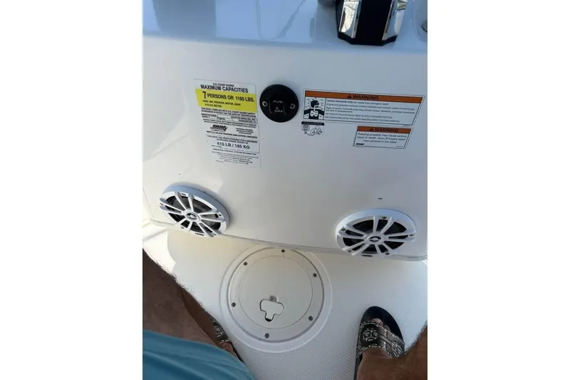 Slide: The Image of Boston Whaler 170 Montauk 2022 boat console with speakers and capacity warning labels. - 7