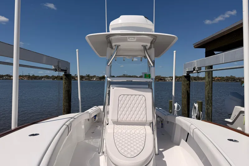 Slide: The Image of 2024 Stoner 23 CC boat docked by a serene lake under a clear blue sky. - 15
