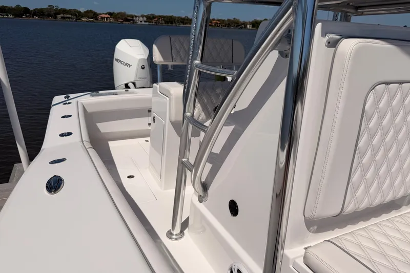 Slide: The Image of 2024 Stoner 23 CC boat interior with white seating and Mercury engine on a calm lake. - 20