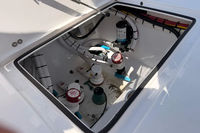 Slide: The Image of 2024 Stoner 23 CC boat compartment with plumbing and wiring components. - 27