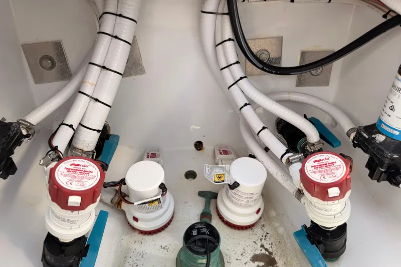 Slide: The Image of 2024 Stoner 23 CC boat plumbing system with hoses and pumps in the bilge area. - 28