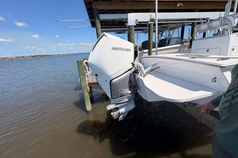 Slide: The Image of 2024 Stoner 23 CC boat with Mercury outboard motor docked by the water. - 7