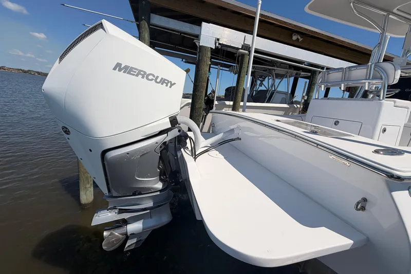 Slide: The Image of 2024 Stoner 23 CC boat with Mercury outboard engine docked by the water. - 8