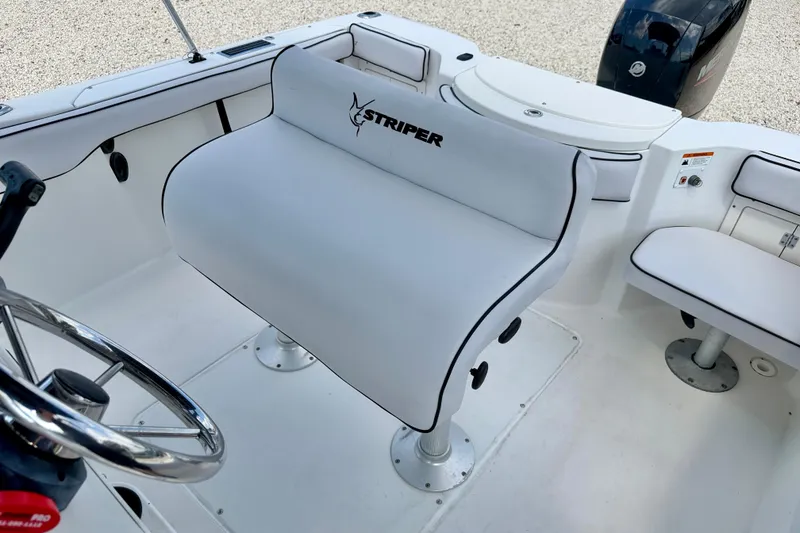 Slide: The Image of 2003 Seaswirl Striper 2101 CC boat interior with white seating and steering wheel. - 12