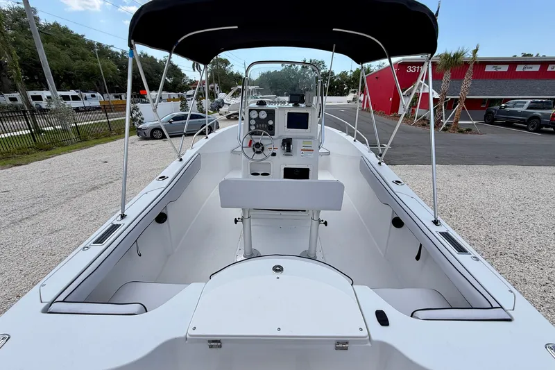 Slide: The Image of 2003 Seaswirl Striper 2101 CC boat interior with console and seating, parked outdoors. - 18