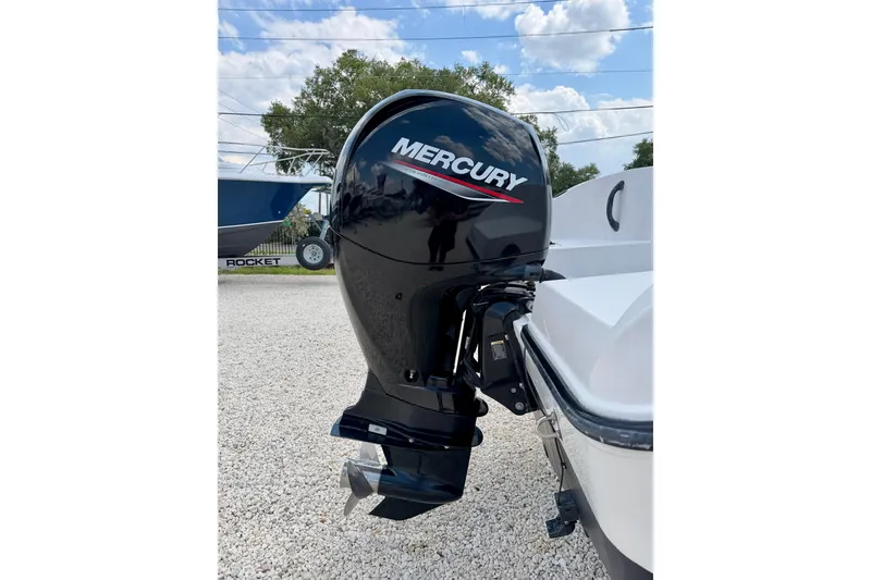 Slide: The Image of 2003 Seaswirl Striper 2101 CC with Mercury outboard motor, parked on gravel. - 27