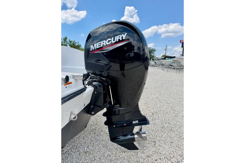 Slide: The Image of Mercury outboard motor on 2003 Seaswirl Striper 2101 CC, parked on gravel lot. - 29
