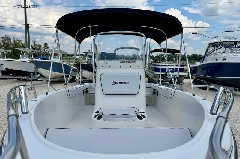 Slide: The Image of 2003 Seaswirl Striper 2101 CC boat with canopy, docked under a cloudy sky. - 8