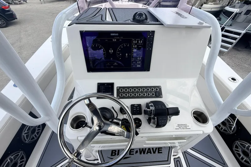 Slide: The Image of 2021 Blue Wave 2800 Makaira boat dashboard with steering wheel and navigation display. - 21