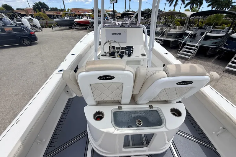 Slide: The Image of 2021 Blue Wave 2800 Makaira boat interior with helm, seating, and storage compartments. - 9