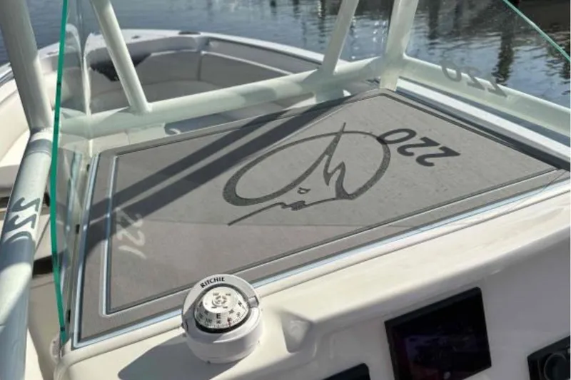 Slide: The Image of 2023 Sailfish 220 CC boat dashboard with compass and logo detail. - 13