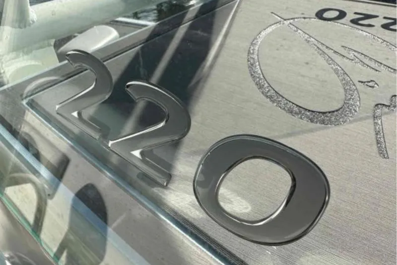 Slide: The Image of 2023 Sailfish 220 CC boat emblem with sleek metallic design. - 14