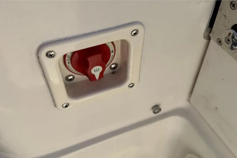 Slide: The Image of Battery switch on 2023 Sailfish 220 CC boat, featuring a red dial and white panel. - 15