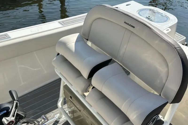 Slide: The Image of 2023 Sailfish 220 CC boat interior with cushioned seating and control panel. - 5