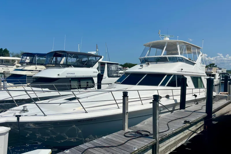 The Image of 1995 Sea Ray 550 Sedan Bridge yacht docked at marina under clear blue sky. - 1