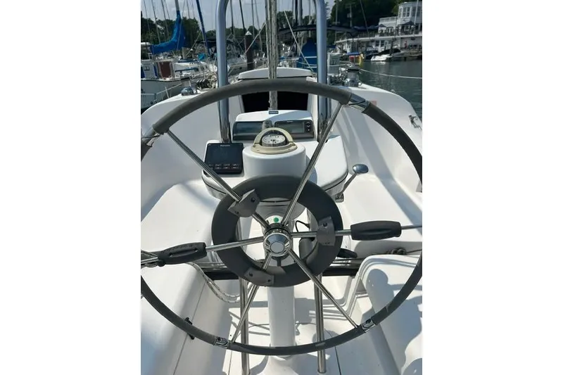 Slide: The Image of Steering wheel of a 2005 Hunter 27 sailboat in a marina setting. - 13