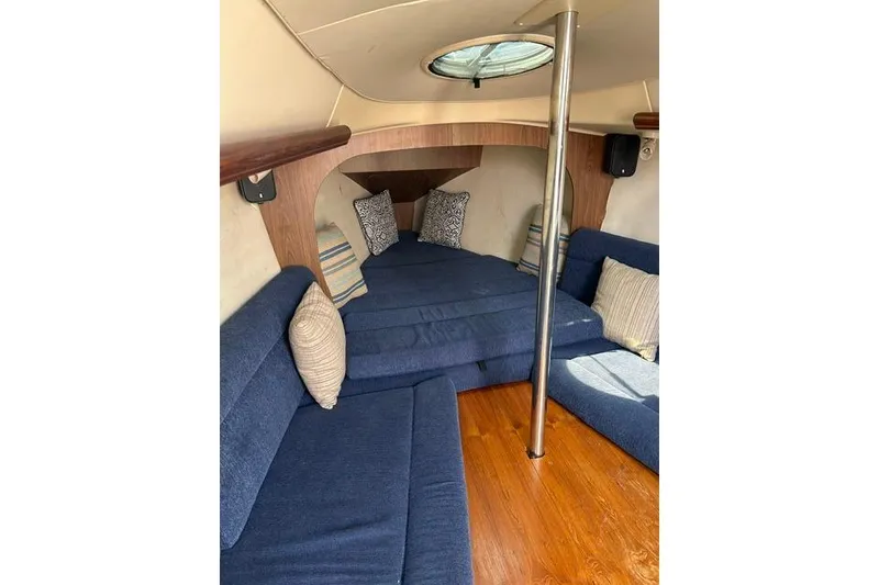 Slide: The Image of Interior of 2005 Hunter 27 sailboat with blue seating and wooden flooring. - 27